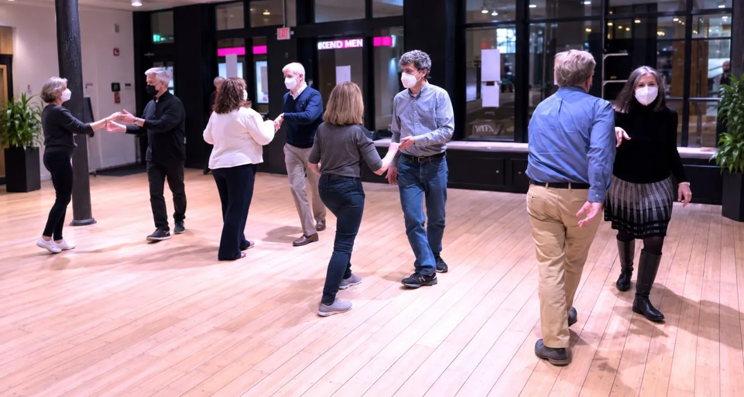 Adults practicing partner steps in pairs during dance classes for adults in Philadelphia, PA