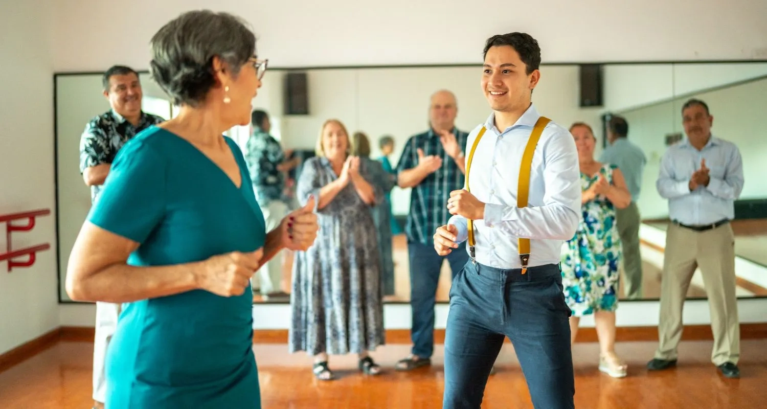 Instructor demonstrating a basic step to an adult student while the rest of the group watches